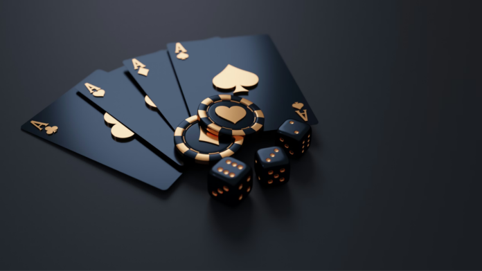 A close up of black playing cars with gold details and three dice. 